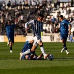 Action-packed soccer game with athletes competing intensely outdoors during the day.