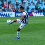 Dynamic shot of a soccer match with players in action on a grassy field.