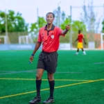 Soccer referee in action on field during a match, guiding players.